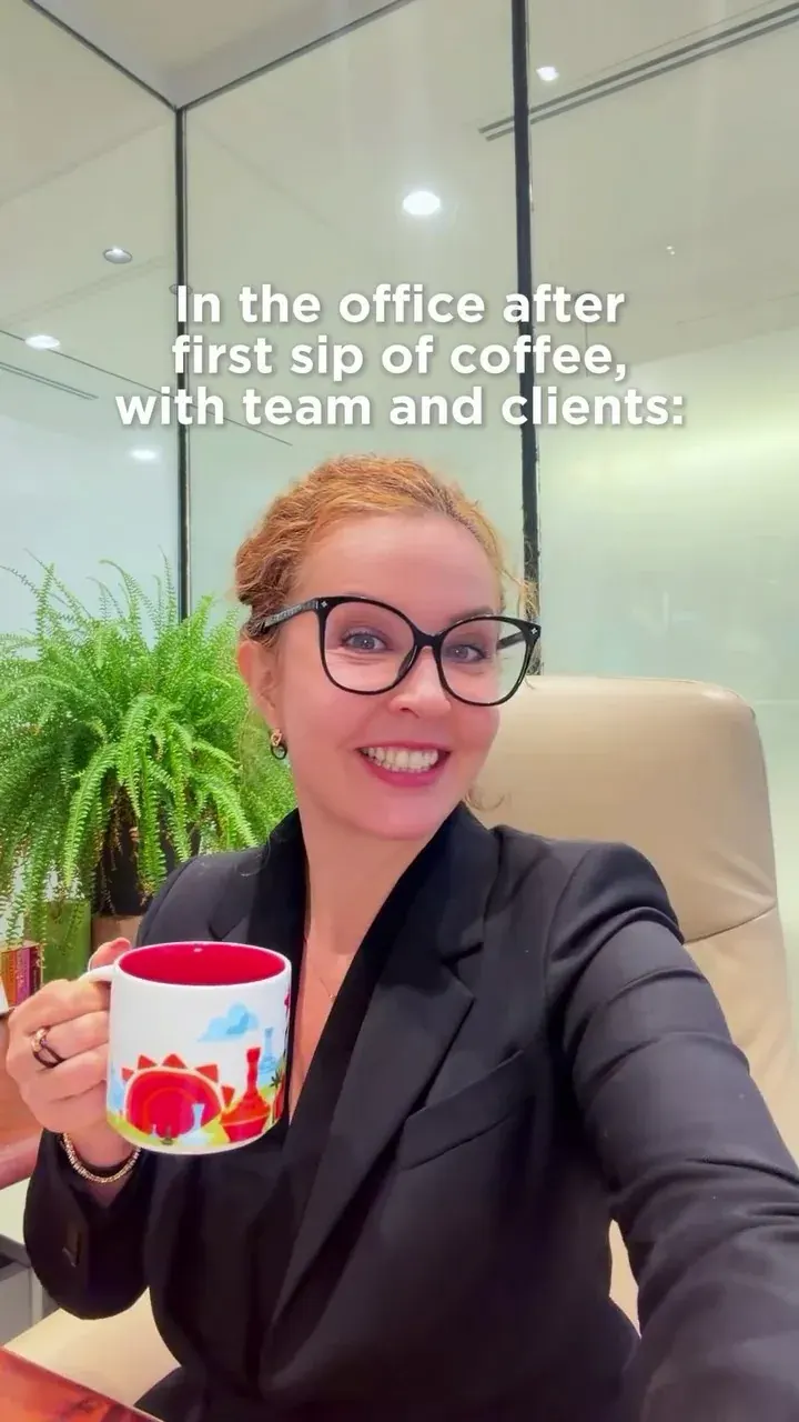 Smiling professional woman with glasses holding a coffee mug in a modern office Smiling professional woman with glasses holding a coffee mug in a modern office